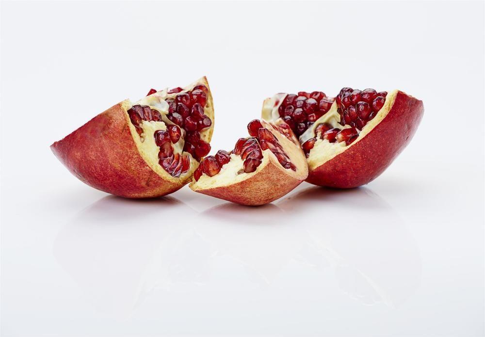 The Fullerton Hotel Sydney Eksteriør bilde The photo shows pomegranate fruit that has been cut into sections. The outer skin is reddish-brown, and the inside reveals juicy, bright red seeds, known as arils. The pieces are arranged on a white surface, highlighting the contrast between the vibr